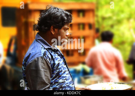 Young man looking outside at lunch time and holding on food Stock Photo