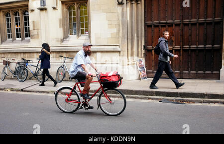 Oxford Oxfordshire UK -  Postman on his bicycle in city centre Stock Photo