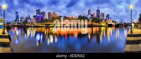 180 degrees panorama of Melbourne city CBD from South Yarra with reflection of bright morning city lights in still river waters. Stock Photo