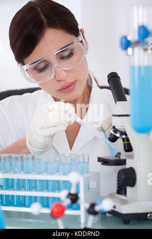 Young Female Scientist Analyzing Sample In Laboratory Stock Photo