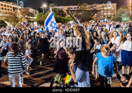 Tel Aviv, Israel. 12th October, 2017. orthodox and secular Jews celebrate Simchat Torah - the Jewish holiday that celebrates and marks the conclusion of the annual cycle of reading of the Torah - old testament, and the beginning of a new cycle. Credit: Michael Jacobs/Alamy Live News Stock Photo