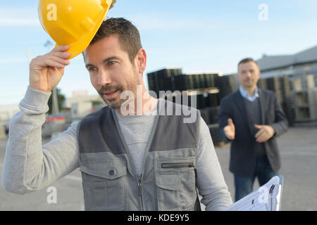 stressed engineer and upset builder walking away Stock Photo