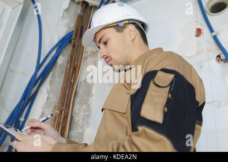 smart pensive builder thinking about something indoors Stock Photo