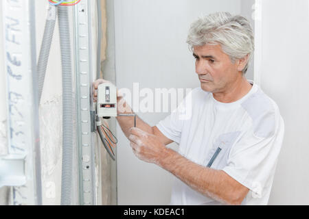 Artisan checking house wiring Stock Photo