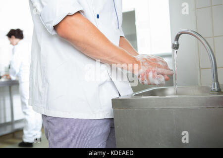 chefs washing hands in an industrial kitchen Stock Photo