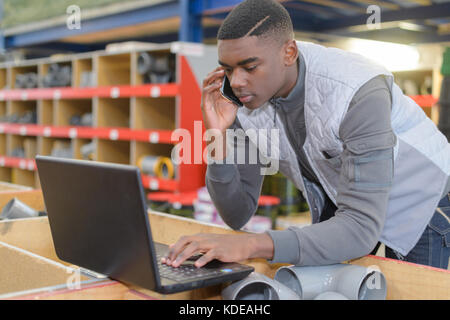 worker checking goods on belt in distribution warehouse Stock Photo