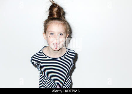 Cute girl showing tongue on a white background Stock Photo