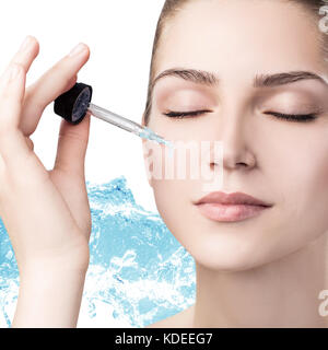 Beautiful woman in splashes of clear blue water. Stock Photo