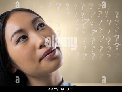 Digital composite of woman looking up at question marks Stock Photo