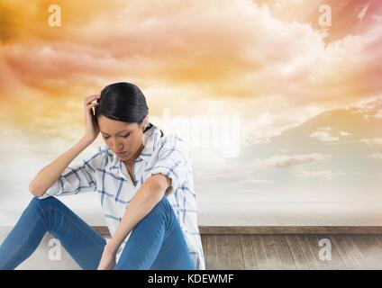 Digital composite of Depressed upset woman sitting with clouds Stock Photo