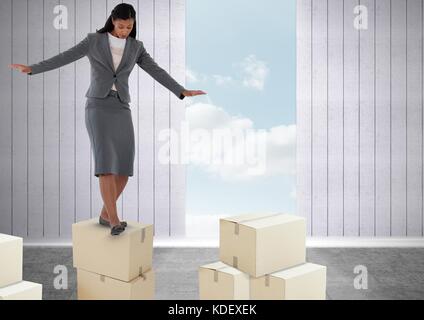 Digital composite of Businesswoman balancing on boxes Stock Photo