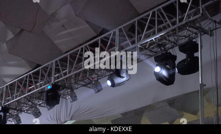 strobe lights emitting different color beams hanging under the ceiling. Stock Photo