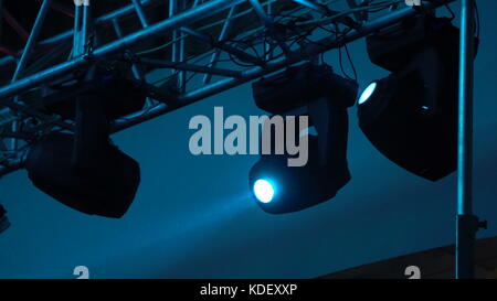 strobe lights emitting different color beams hanging under the ceiling. Stock Photo