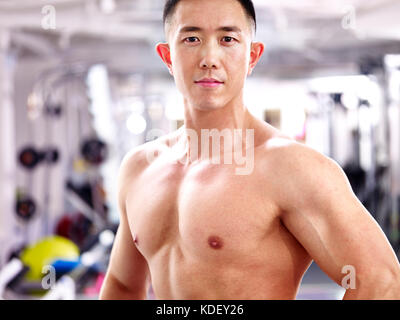 portrait of a young asian bodybuilder in fitness center. Stock Photo