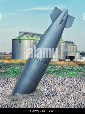 close up on misfire or unexploded  bomb with the factory on background Stock Photo