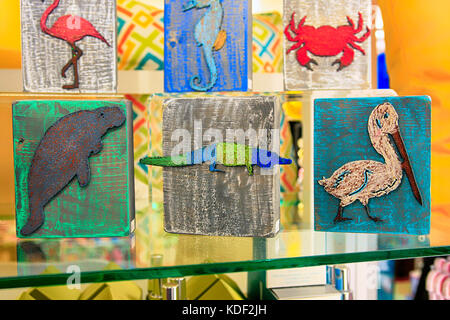 Handmade plaques of dolphins, seashells, turtles, sand dollars and palm trees home decor ornatments on sale in a store in Florida USA Stock Photo