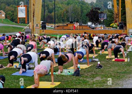 An outdoors yoga class at Mont Sainte Anne in Quebec Canada Stock Photo