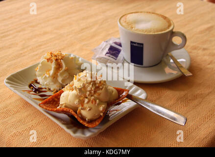 https://l450v.alamy.com/450v/kdg7my/cappucino-coffee-and-cream-cake-on-small-white-plates-on-plain-textured-kdg7my.jpg