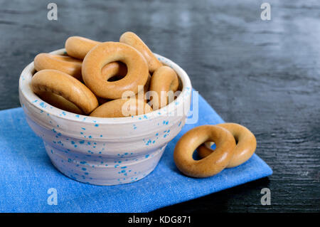 Small crispy bagels in a ceramic bowl on a black background. Snack. Stock Photo