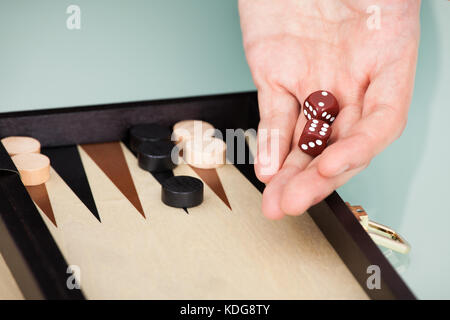 Close-up Of Person's Hand Holding Dice Playing Backgammon Stock Photo