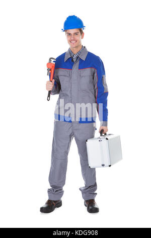 Portrait Of Male Worker Holding Wrench And Toolkit On White Background Stock Photo