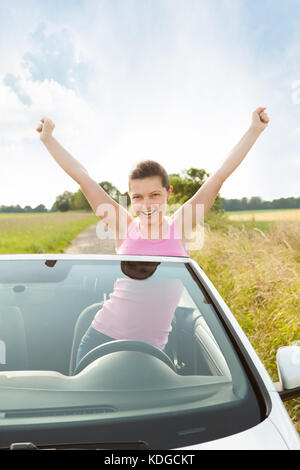 Happy Woman Raising Hand In Car While Travelling Stock Photo