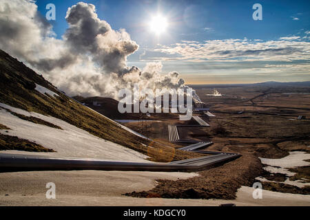 Hellisheidi geothermal powerplant in iceland, shot in evening sun in spring. Pipes leading to the power plant in the distance Stock Photo