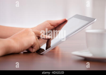 Close-up Of Woman Hand Holding Digital Tablet With Cup Stock Photo