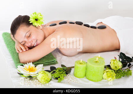 Young Happy Woman Getting Hot Stone Massage In Spa Stock Photo