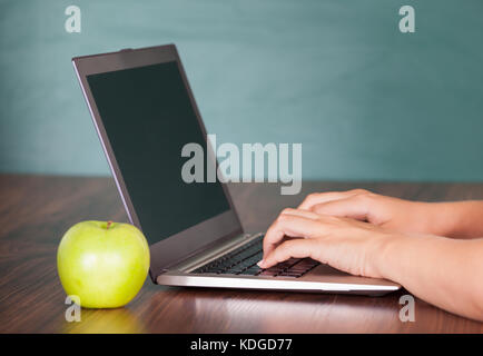Close-up of human hand using laptop on desk Stock Photo