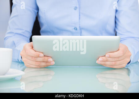 Close-up Of A Businesswoman Using Digital Tablet At Desk Stock Photo