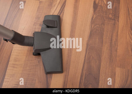 Close-up Of Vacuum Cleaner Cleaning Hardwood Floor Stock Photo