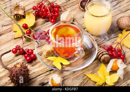 cup of berry tea with a mulberry on background with autumn leaves Stock Photo