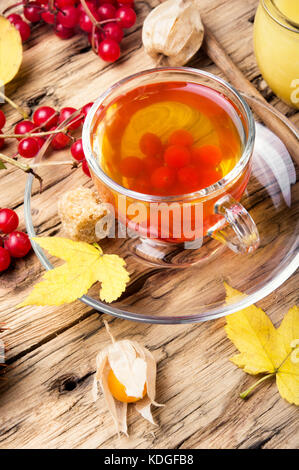 cup of berry tea with a mulberry on background with autumn leaves Stock Photo