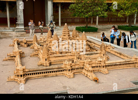 PHNOM PENH, CAMBODIA - FEBRUARY 21, 2013: Tourists are taking pictures of a miniature model of temple of Angkor Wat in the Royal Palace Stock Photo