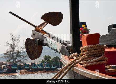 Old rusty anchor on a bow of the Cambodian fishing boat Stock Photo