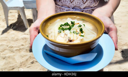 Thai chicken noodle soup served at the beach - selective focus Stock Photo