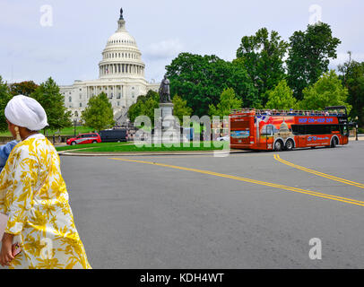The US Capitol Building with sightseeing bus and  woman in traditional African dress with head tie in Washington, DC, USA Stock Photo