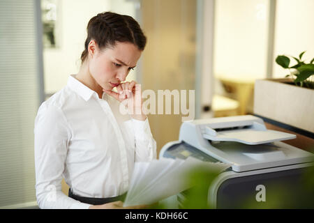 Pensive secretary or accountant reading financial documents in office Stock Photo