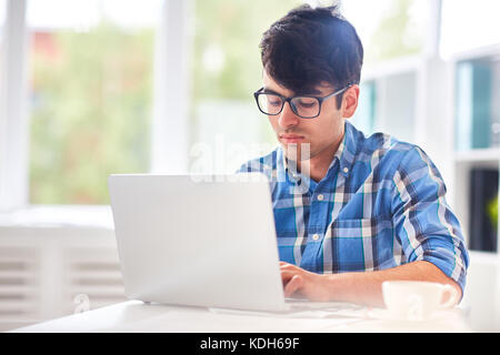 Modern guy typing on laptop while analyzing data in the net Stock Photo