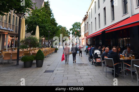 Ulm, Germany - 28th July 2017: People eating dinner in a restaurant behind Ulm Minster