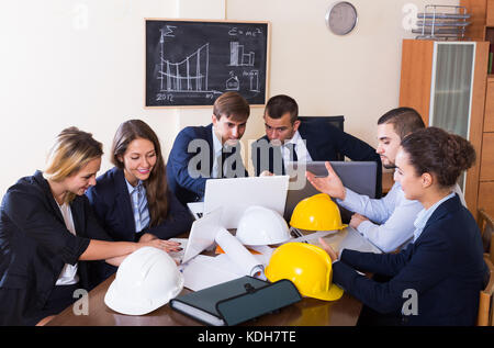 smiling team of architects working and brainstorming in office Stock Photo
