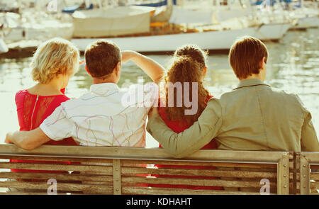 Normal ordinary family of four enjoying the sunny spring day together near sea Stock Photo