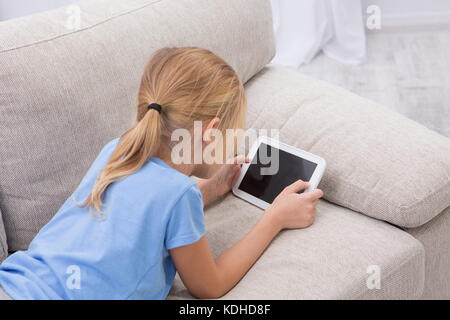Sick child staying at home palying games on tablet. Stock Photo
