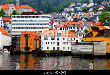 Bergen, Norway - the colors of the wooden warehouses in the port make colorful reflections on the water in landscape format Stock Photo