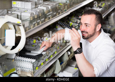 Portrait of adult man selecting equipment in household department Stock Photo