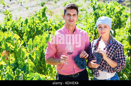 Two  friendly farmers posing with wine and grape at summertime Stock Photo