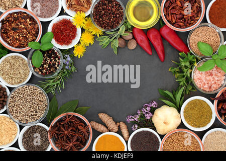 Herb and spice background border with fresh and dried herbs and spices on slate. Stock Photo