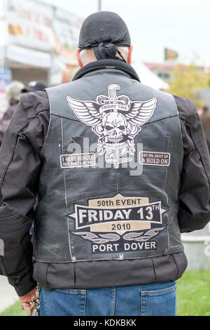 Port Dover, Ontario, Canada, 13th October 2017. Thousands of motorcyclists from all over Canada and the USA get together for The Friday 13th Motorcycle Rally, held every Friday the 13th in Port Dover, Ontario, Canada, since 1981. The event is one of the largest single-day motorcycle events in the world. The mild weather contributed for a large number of bikers and onlookers, with hundreds of custom motorcycles, vendors, live music and interesting people to watch. Back of a male Harley Davidson enthusiast leather jacket decorated with patches and badges. Credit: Rubens Alarcon/Alamy Live News Stock Photo