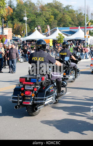 Port Dover, Ontario, Canada, 13th October 2017. Thousands of motorcyclists from all over Canada and the USA get together for The Friday 13th Motorcycle Rally, held every Friday the 13th in Port Dover, Ontario, Canada, since 1981. The event is one of the largest single-day motorcycle events in the world. This year, the mild weather contributed for a large number of bikers and onlookers, with hundreds of custom motorcycles, vendors, live music and interesting people to watch. Ontario Provincial Police (OPP) officers on motorcycles patrolling Main Street. Credit: Rubens Alarcon/Alamy Live News Stock Photo